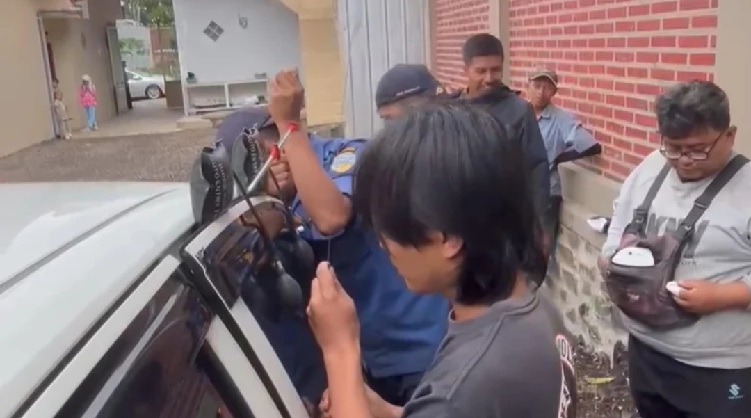 Petugas Damkar Kota Tasikmalaya saat membuka paksa pintu mobil untuk mengevakuasi anak kecil yang terjebak dalam mobil.